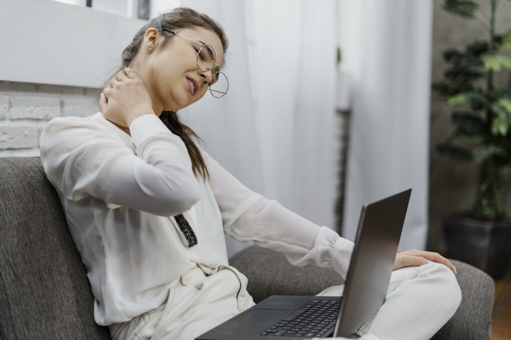 woman having neckache as she works home